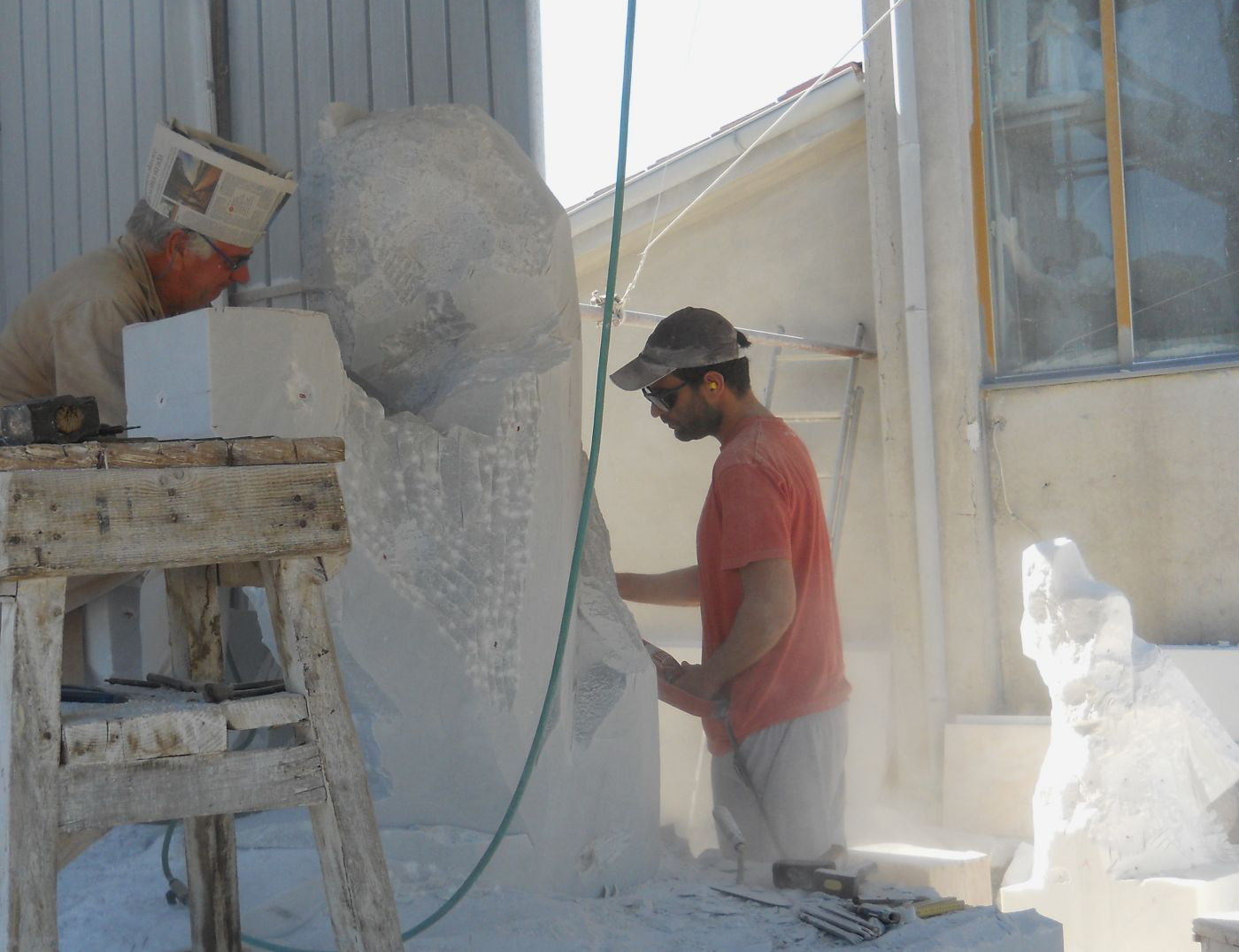 Ulderigo and Alberto Giannoni rough-carving marble blocks side by side in the Pietrasanta studio
